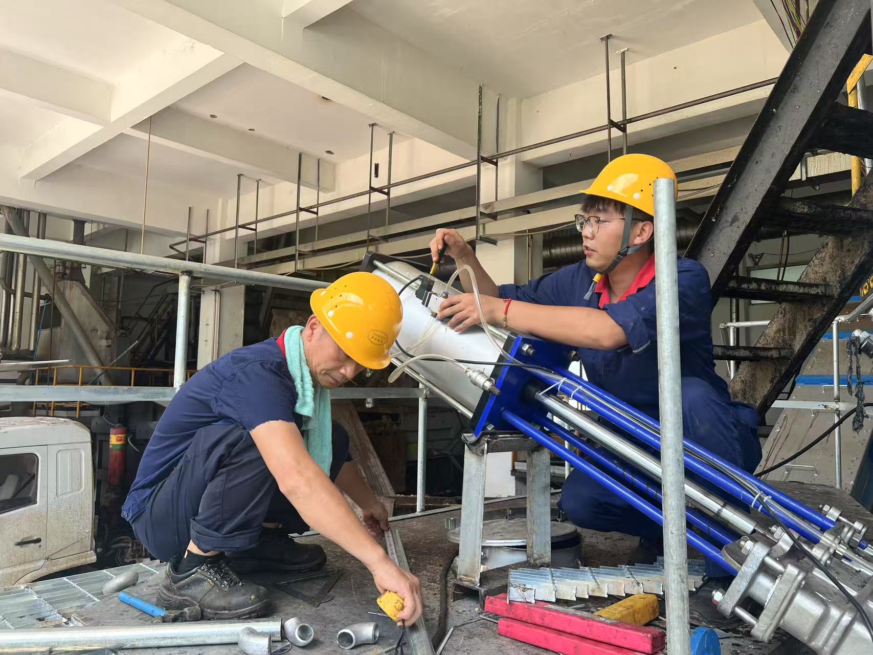 諶瀟毅（右一）和同事在進行氣動泵維修.jpg